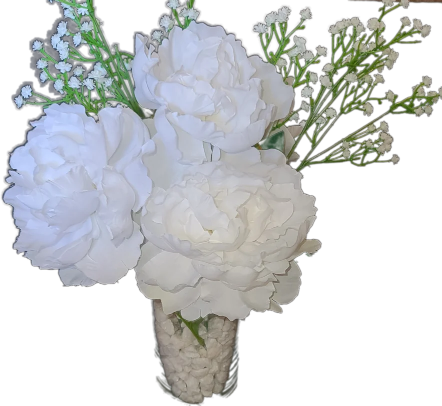 White peonies and baby's breath in a glass vase filled with white stones